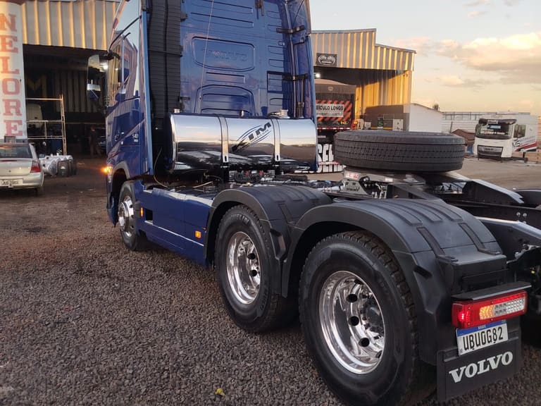 Volvo FH azul com kit hidráulico Kim Comandos instalado, visto de trás no pátio